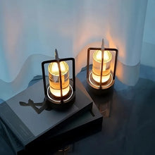 Two black rechargeable metal lamps glowing warmly with a crystal-like centerpiece, elegant home lighting.