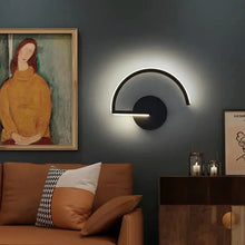 Arc LED wall light in a modern living room above a brown sofa