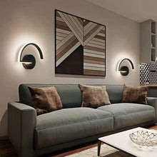 Two arc LED wall sconces lighting up a stylish living room with a sofa and decor