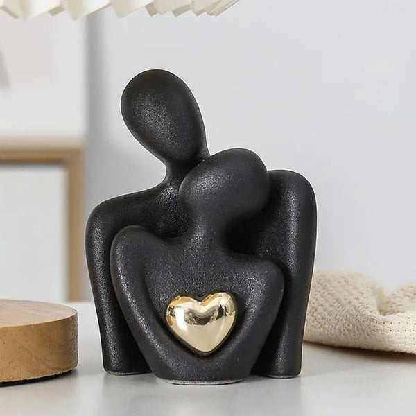 Elegant black ceramic couple statue with a golden heart, perfect for modern home decor and meaningful gifts.