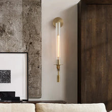 Brass wall light mounted in a modern living room, blending with industrial and wooden decor.