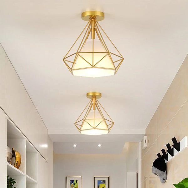 Two gold Robin cage ceiling fixtures mounted in corridor with minimal decor.