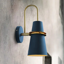 Close-up of a blue and gold modern wall lamp with a minimalist cone-shaped lampshade and gold metal frame.