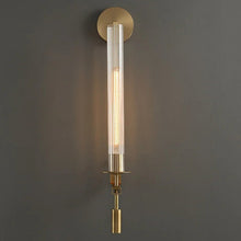 Close-up of a brass wall light fixture, showcasing its smooth metal finish and detailing.