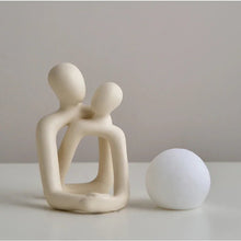 LED table lamp featuring a ceramic couple figurine with a glowing sphere, adding warmth to any space.