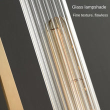 Detailed view of a glass lampshade on a brass wall light, highlighting its fine texture.