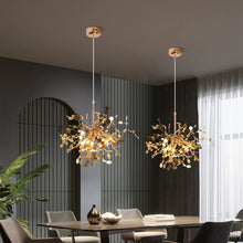 Gold modern chandeliers suspended above a sleek dining table, adding a touch of elegance and luxury to the dining space.