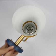 Inside view of a modern wall lamp showing the bulb holder and gold fixture details with a white interior.