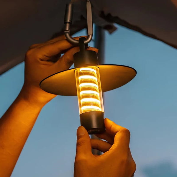 A person hanging the LumiTrail light under a tent, demonstrating its multipurpose use.