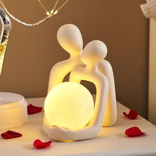 Modern decorative table lamp with a romantic couple design, featuring a warm glowing sphere for cozy home decor.