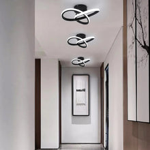 Three black LED ceiling lamps aligned in a modern hallway, offering a sleek, energy-efficient lighting solution.