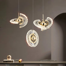 Three Ånd Lys pendant lights hanging over a sleek dining area, showcasing their unique glowing crystal design.