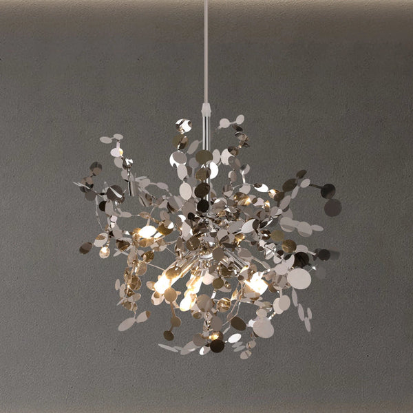 Silver crystal chandelier hanging against a minimalist textured wall, emitting soft warm light for an elegant interior atmosphere.