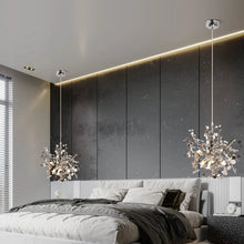 Elegant silver modern chandeliers hanging above a bed in a luxurious, dark-themed bedroom.