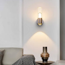Elegant Luxor wall sconce installed in a living room above a side table, casting soft ambient light.
