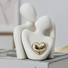 Stylish white ceramic couple statue set with a golden heart, ideal for home decoration and anniversary gifts.